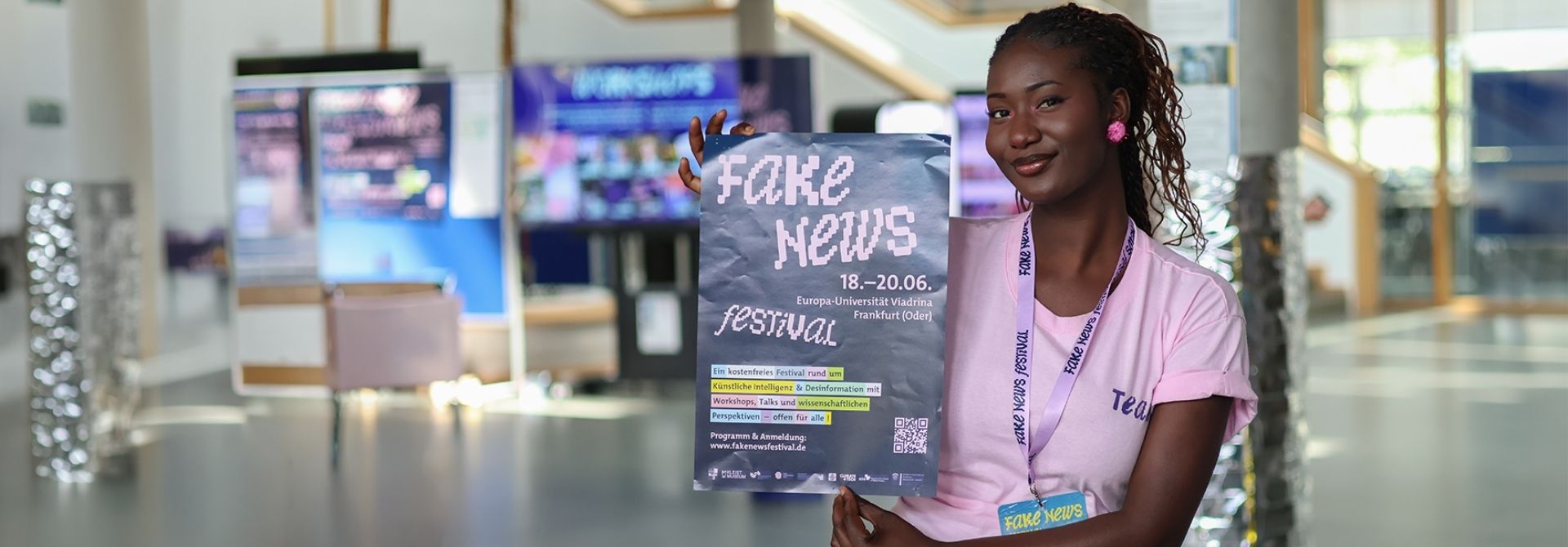 Studentin hält das Plakat zum Fake News Festival an der Viadrina hoch