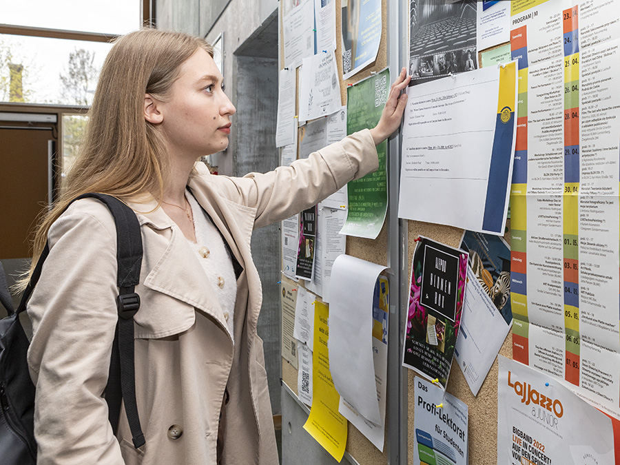 Viadrina student reads notices on bulletin board
