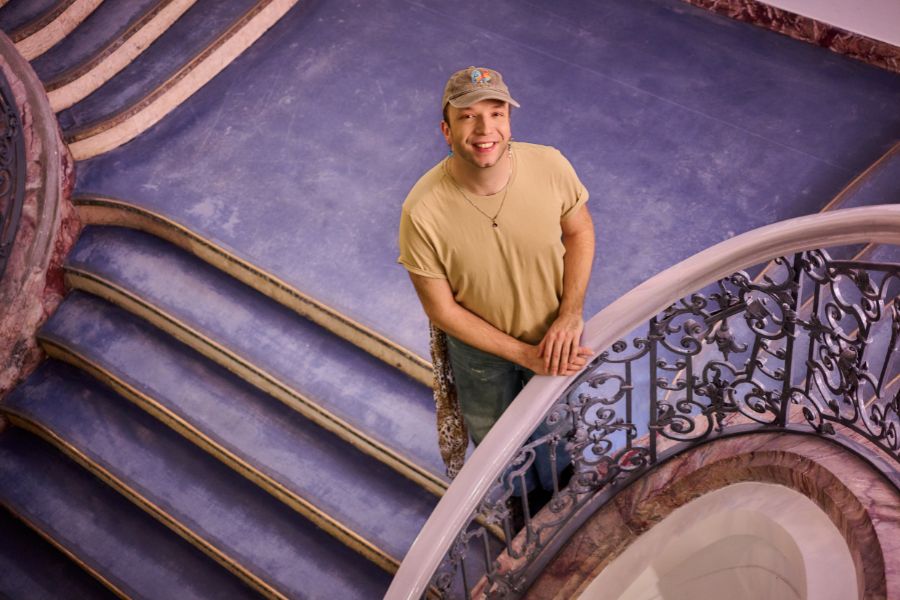 Student im Treppenhaus des Hauptgebäudes des Viadrina