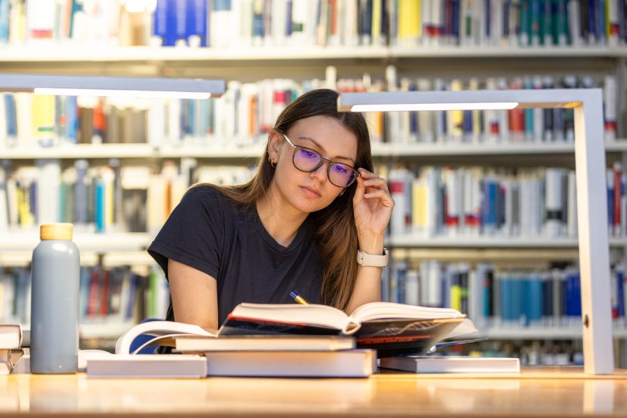 Studentin liest Bücher, Bibliothek